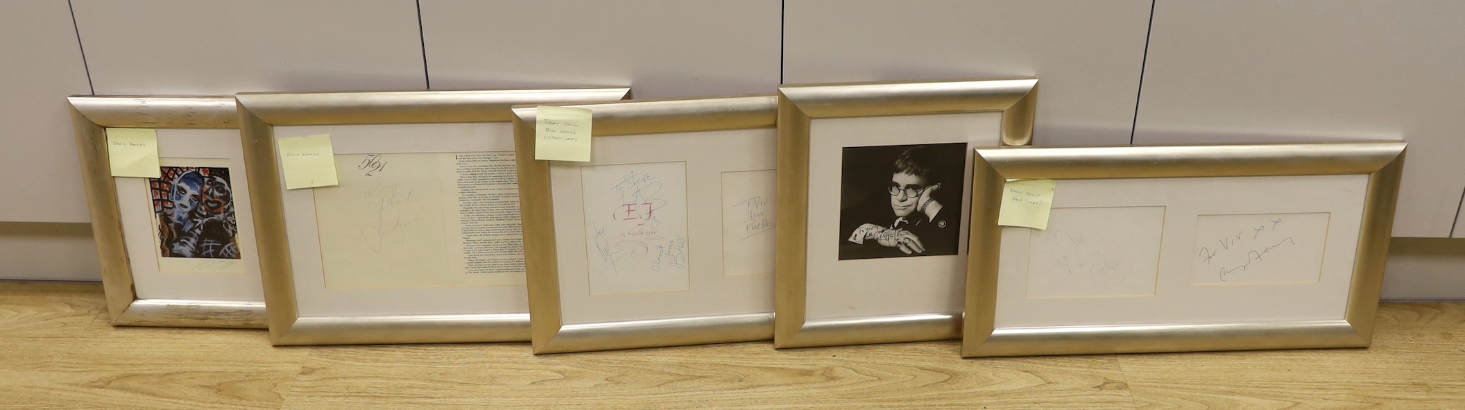 A collection of mostly framed autographs to include an event card from Elton John, 25 March 1994 signed by Charlie Watts, Jerry Hall and Jerry Hall, together with autographs by David Bowie, Phil Collins, David Bailey, Da